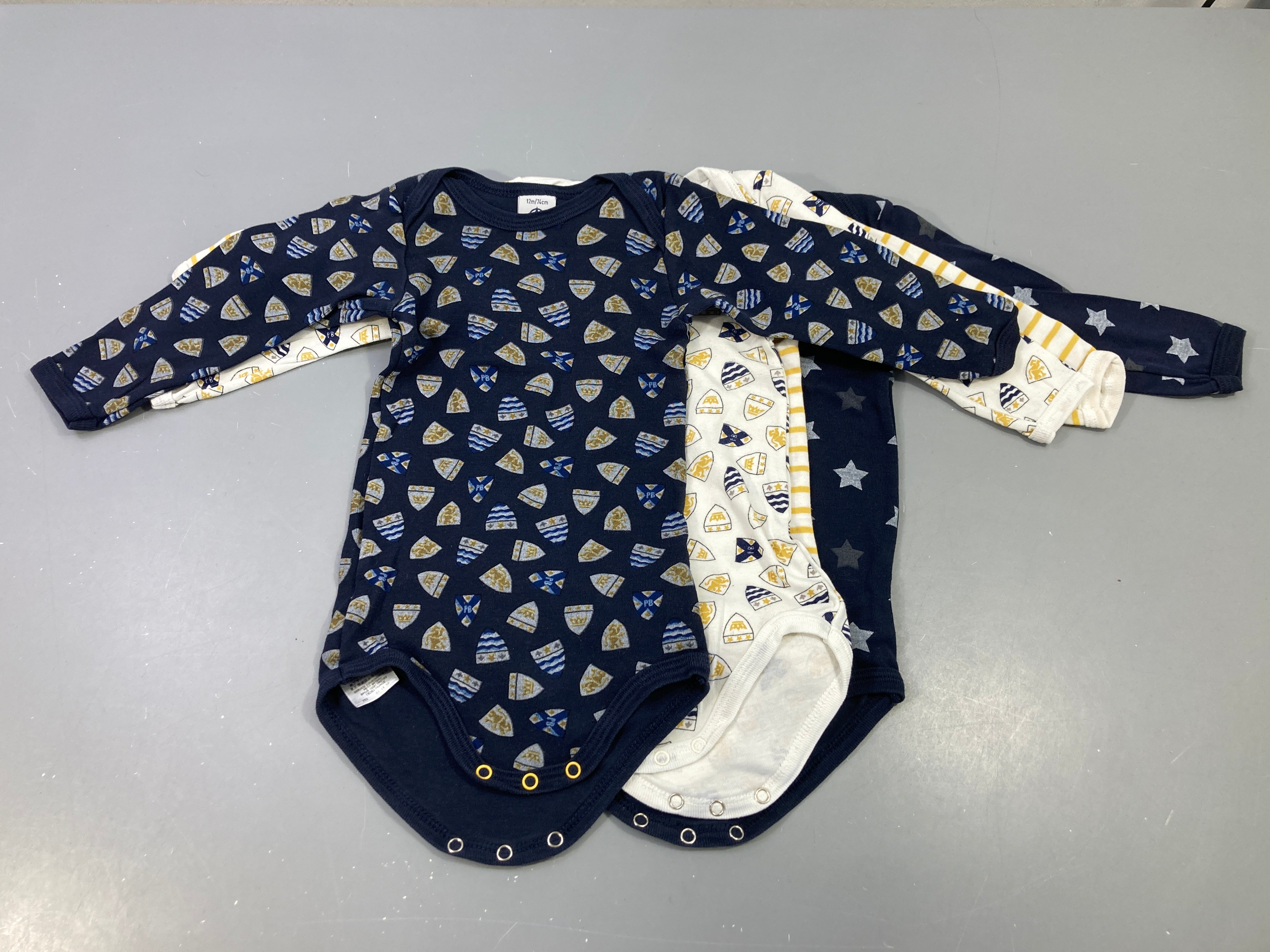 Lot  de 4 bodies m.l bleu foncé et blanc avec motifs, blanc rayé jaune, bleu étoiles