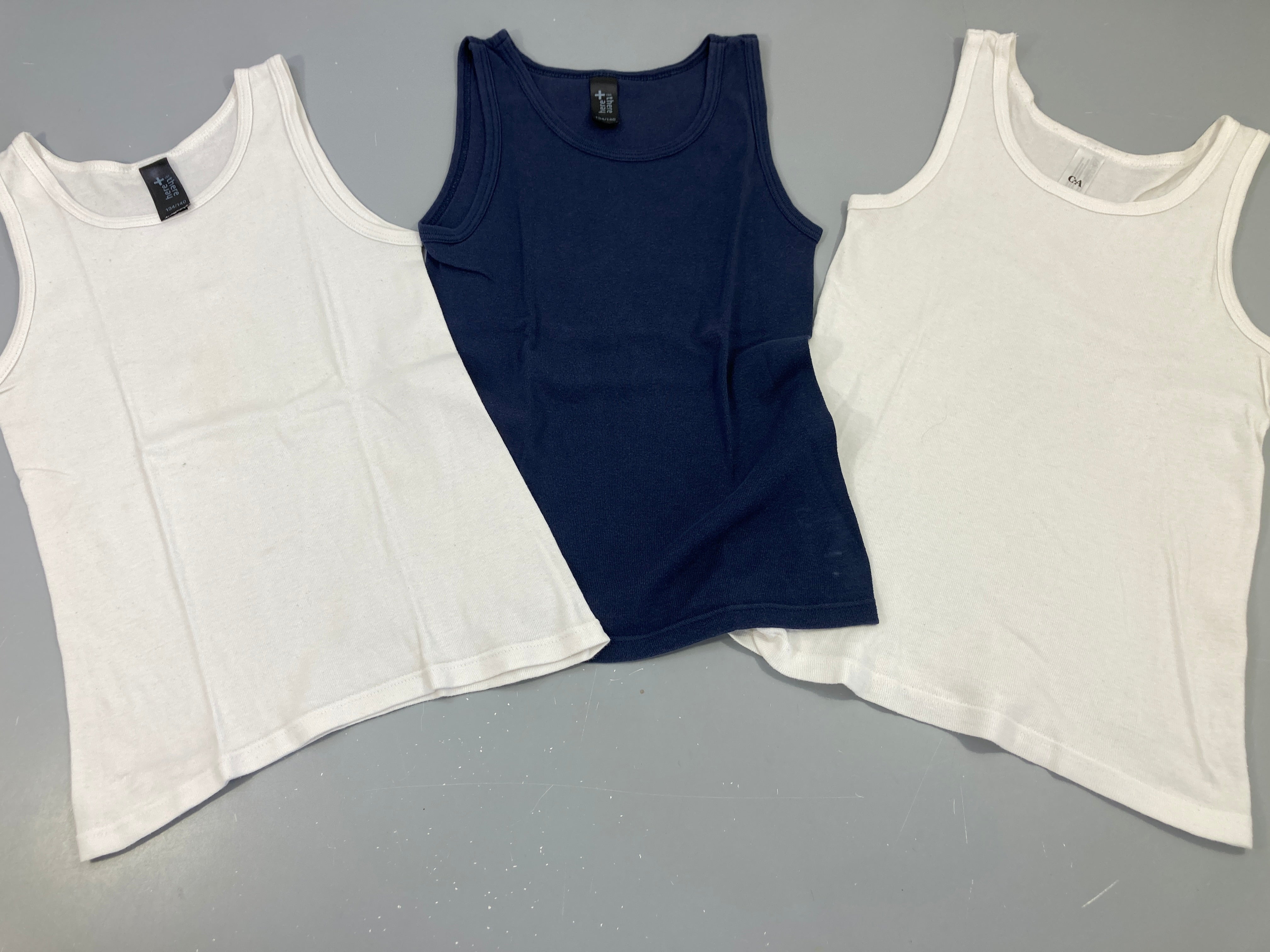 3 chemisettes s.m, 2 blanches et 1 bleu marine, légèrement boulochées