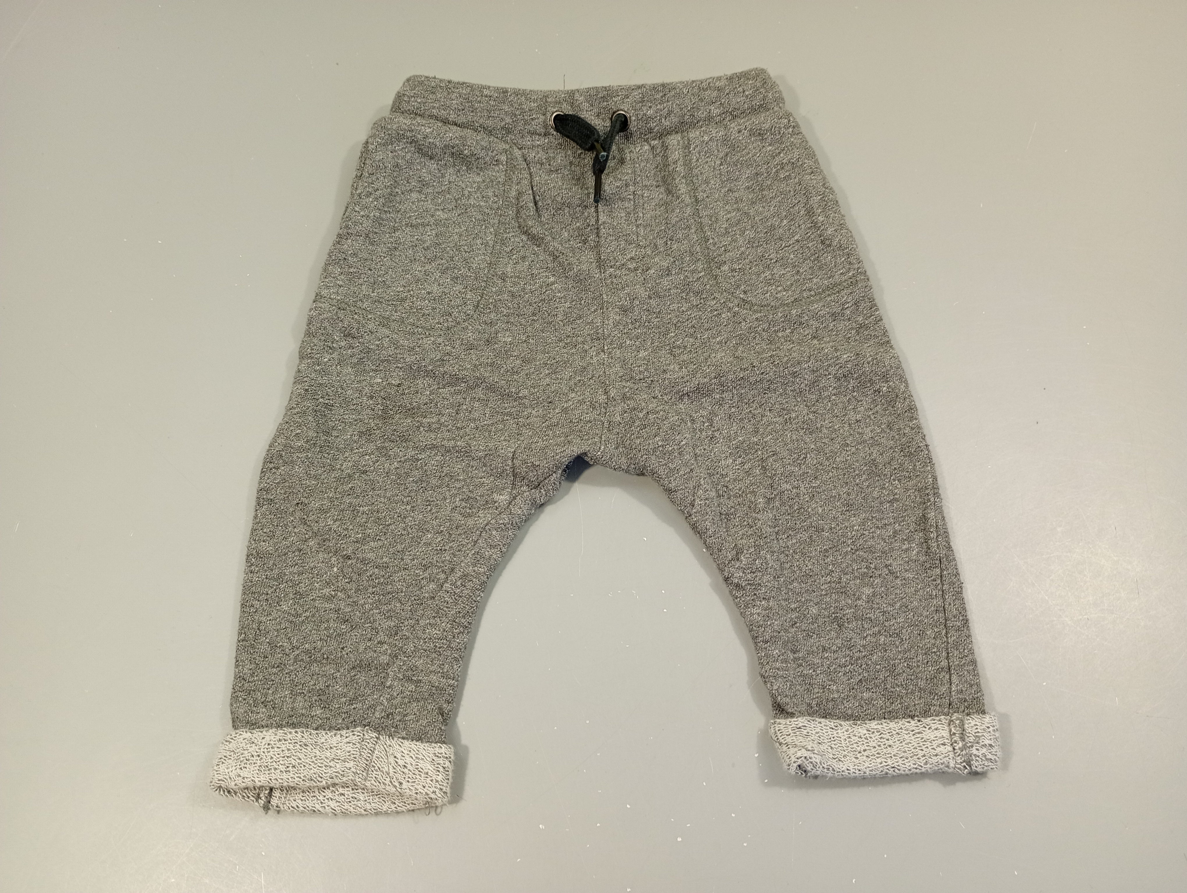 Pantalon molleton gris chiné à revers. Très légèrement bouloché