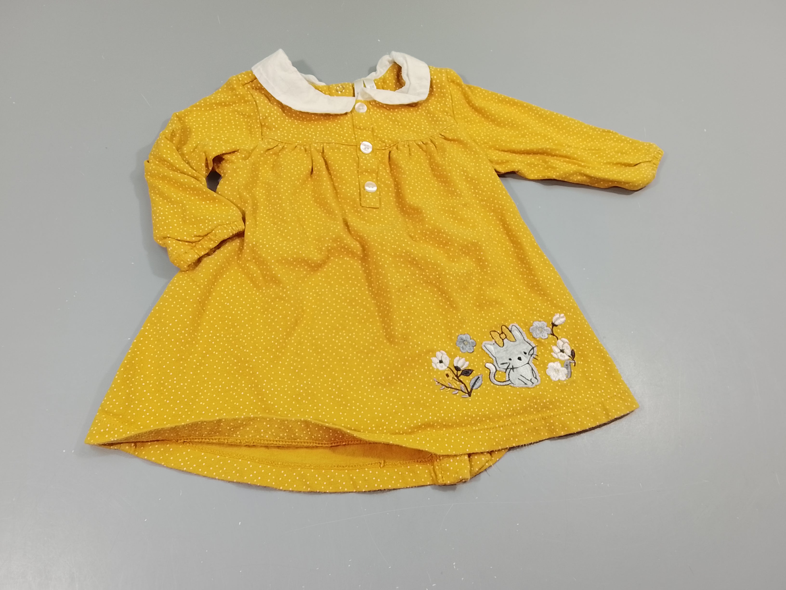 Robe m.l jaune à pois blancs, broderie chaton,col blanc .Fermeture par pressions à l'arrière