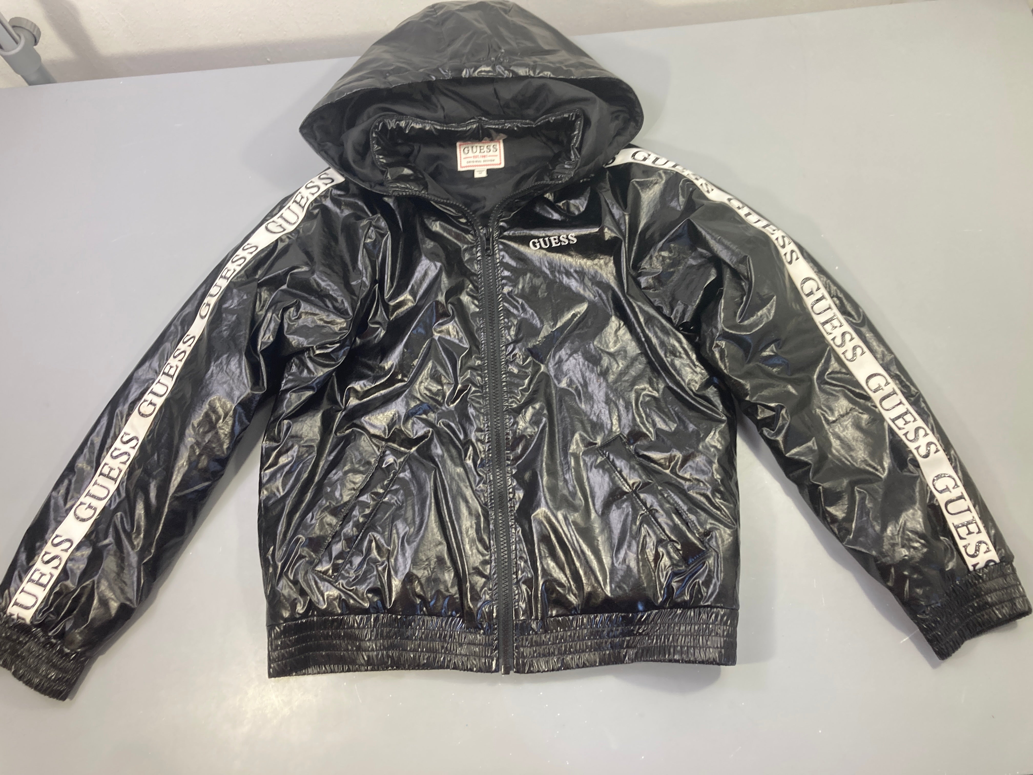 Veste noire à capuche Guess quelques tache  sur bandes blanches