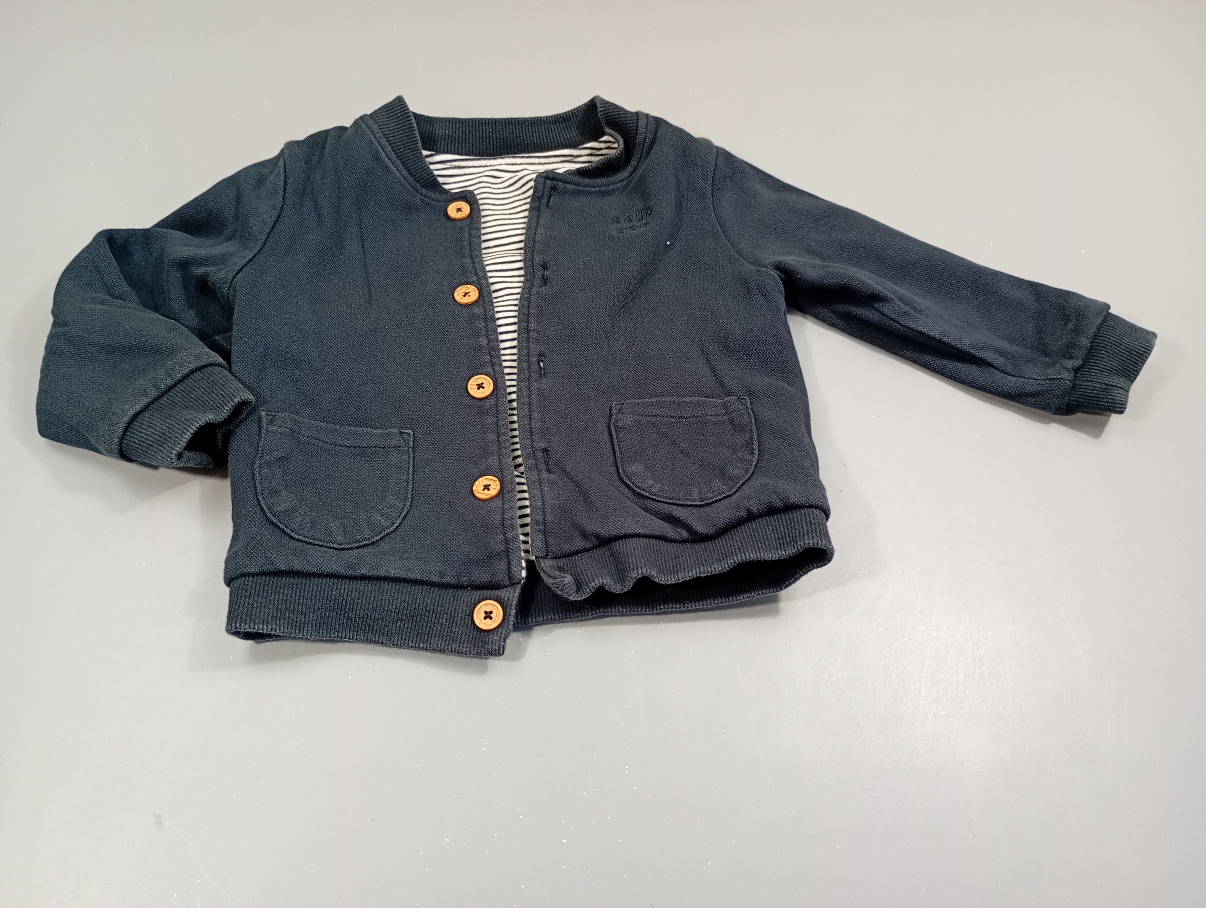 Gilet réversible bleu marine texturé/blanc rayé bleu. Pas de taille indiquée, estimée  18m