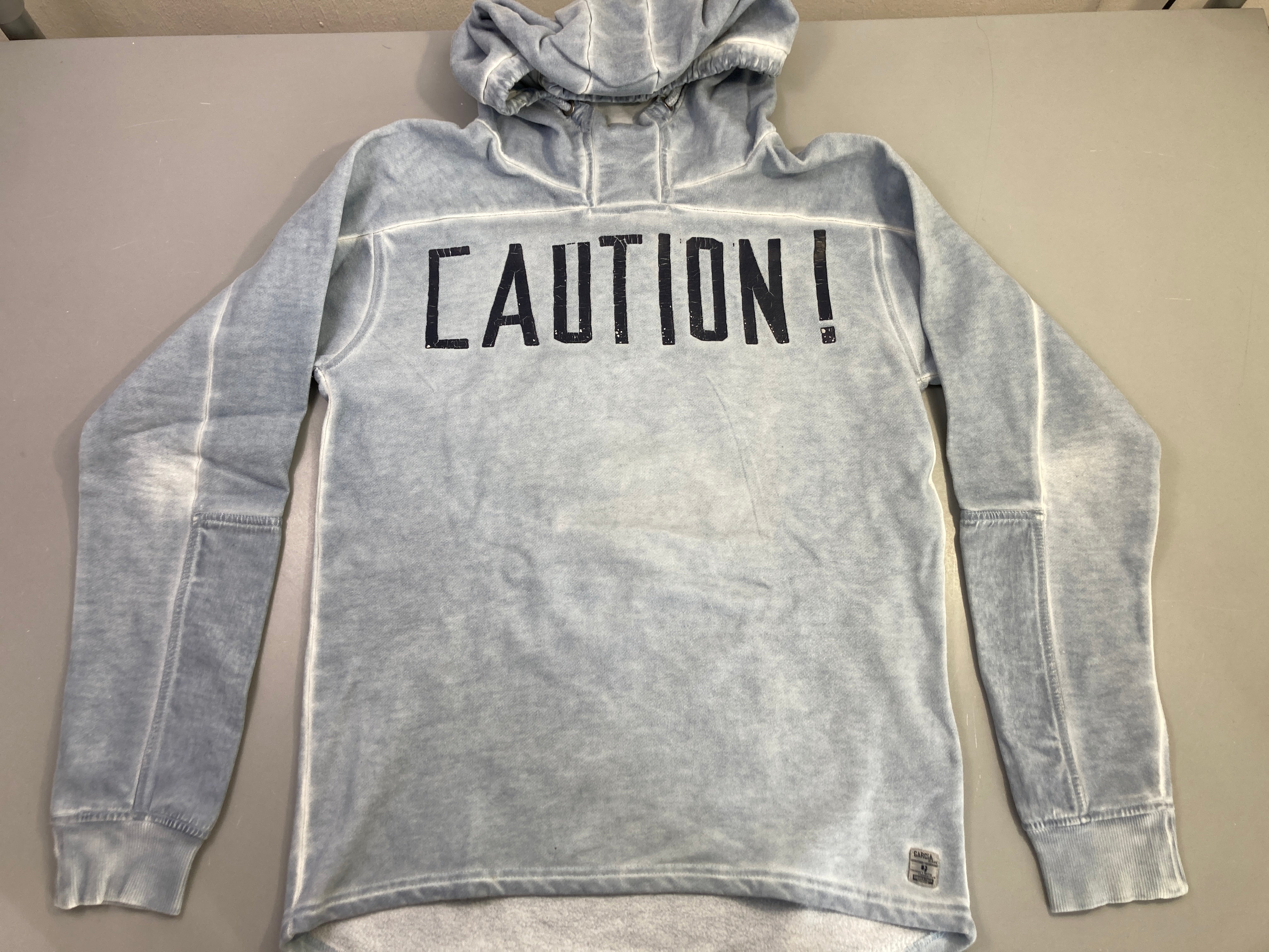 Sweat capuche gris imprimé craquelé CautioLégèrement bouloché