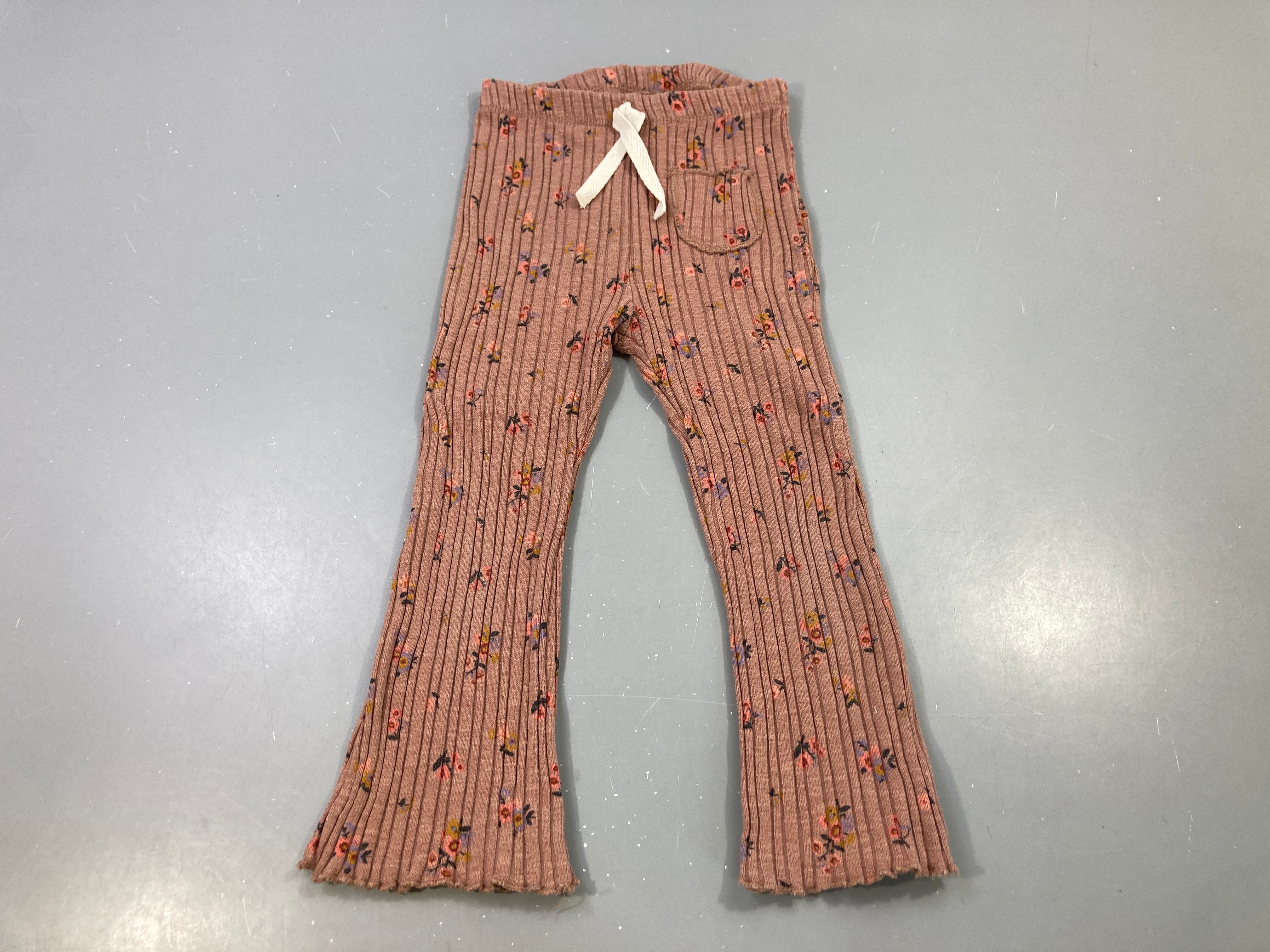 Pantalon évasé mailles rose poudré fleuri, légèrement bouloché