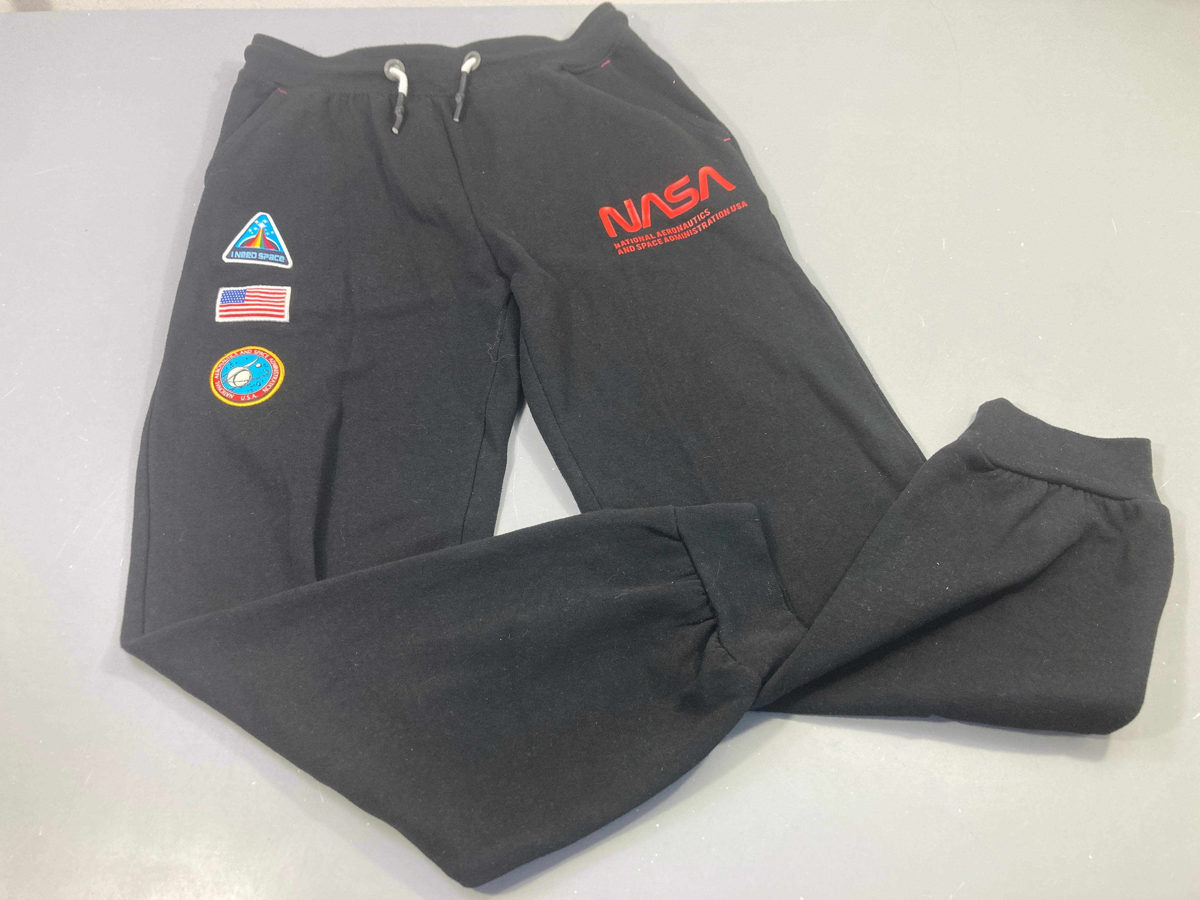 Jogging noir Beyond, Therainbow, écussons Nasa,très légèrement bouloché