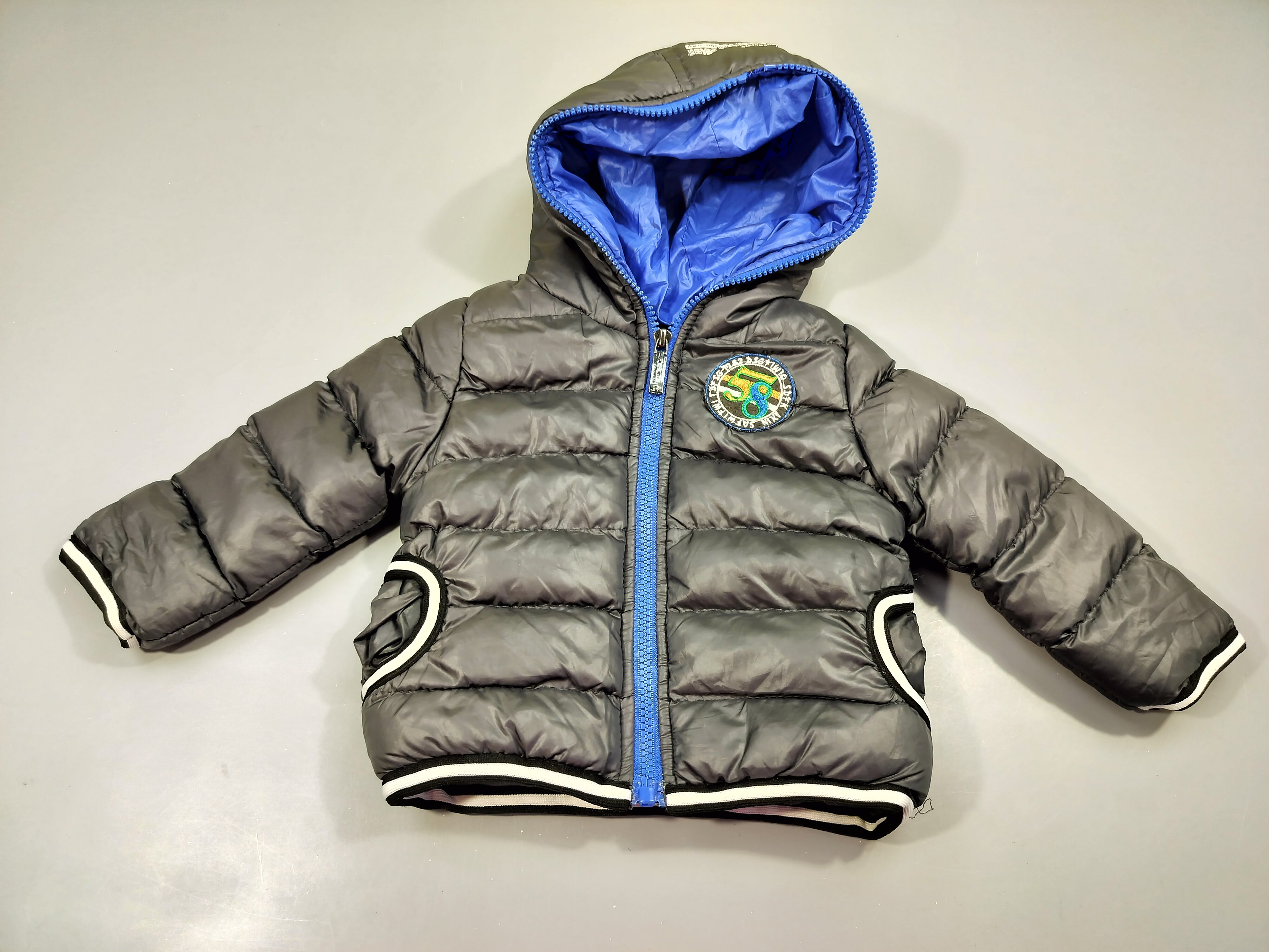 Veste zippée à capuche matelassée gris irrisé. zip bleu, intérieur polar