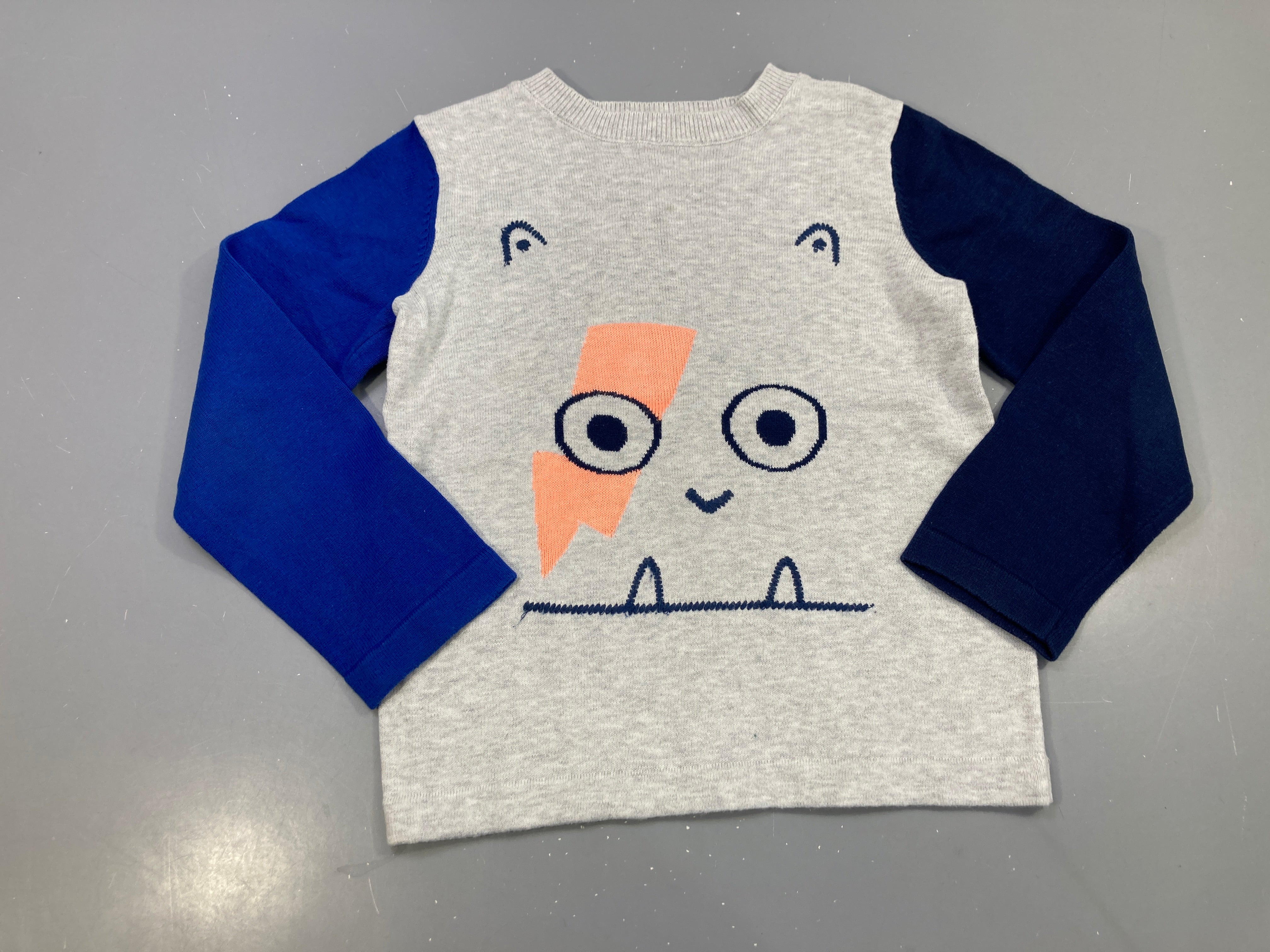 Pull gris chiné, manches bleues, motif monstre