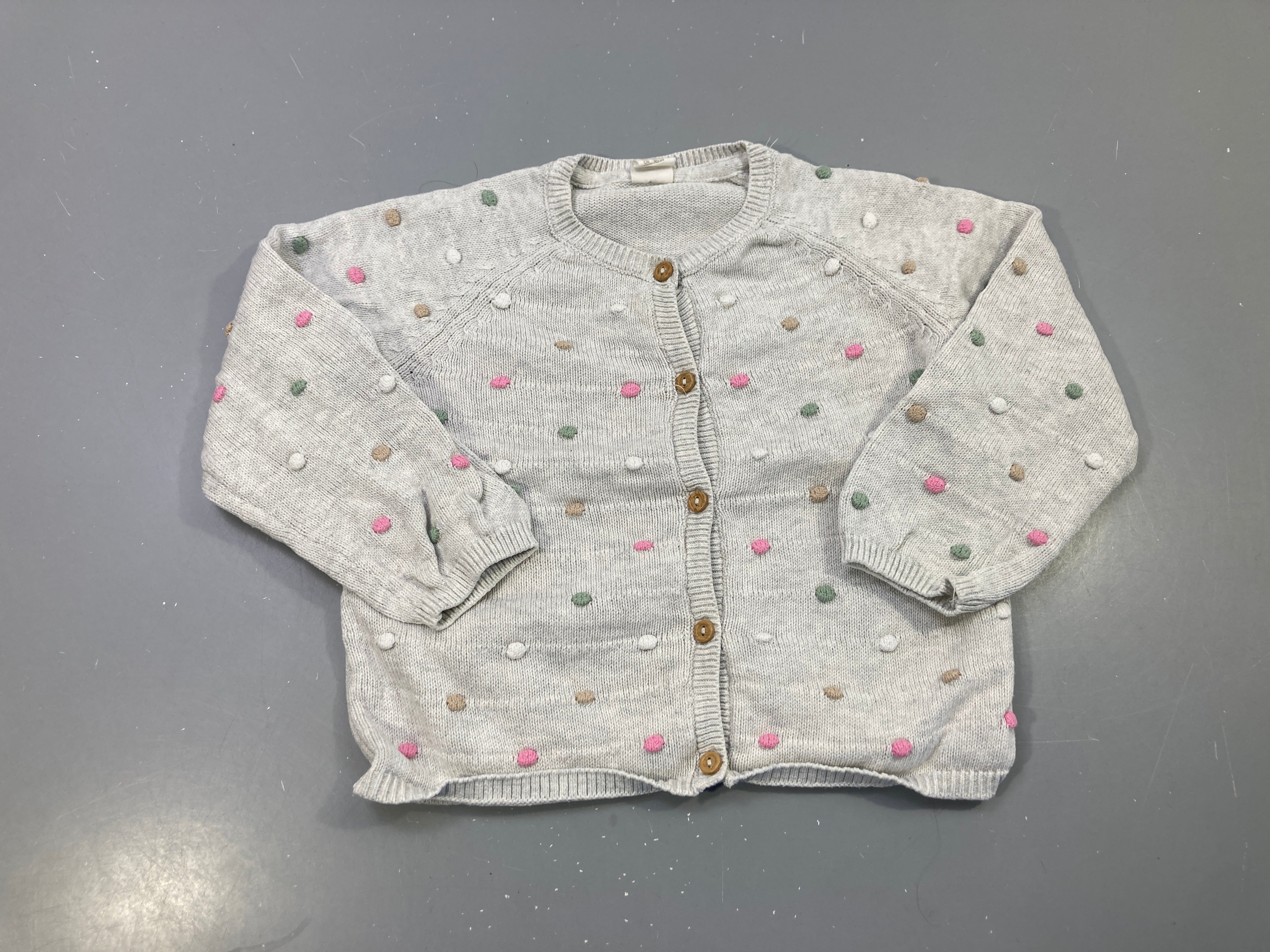 Gilet gris chiné maille, pompons roses verts beiges