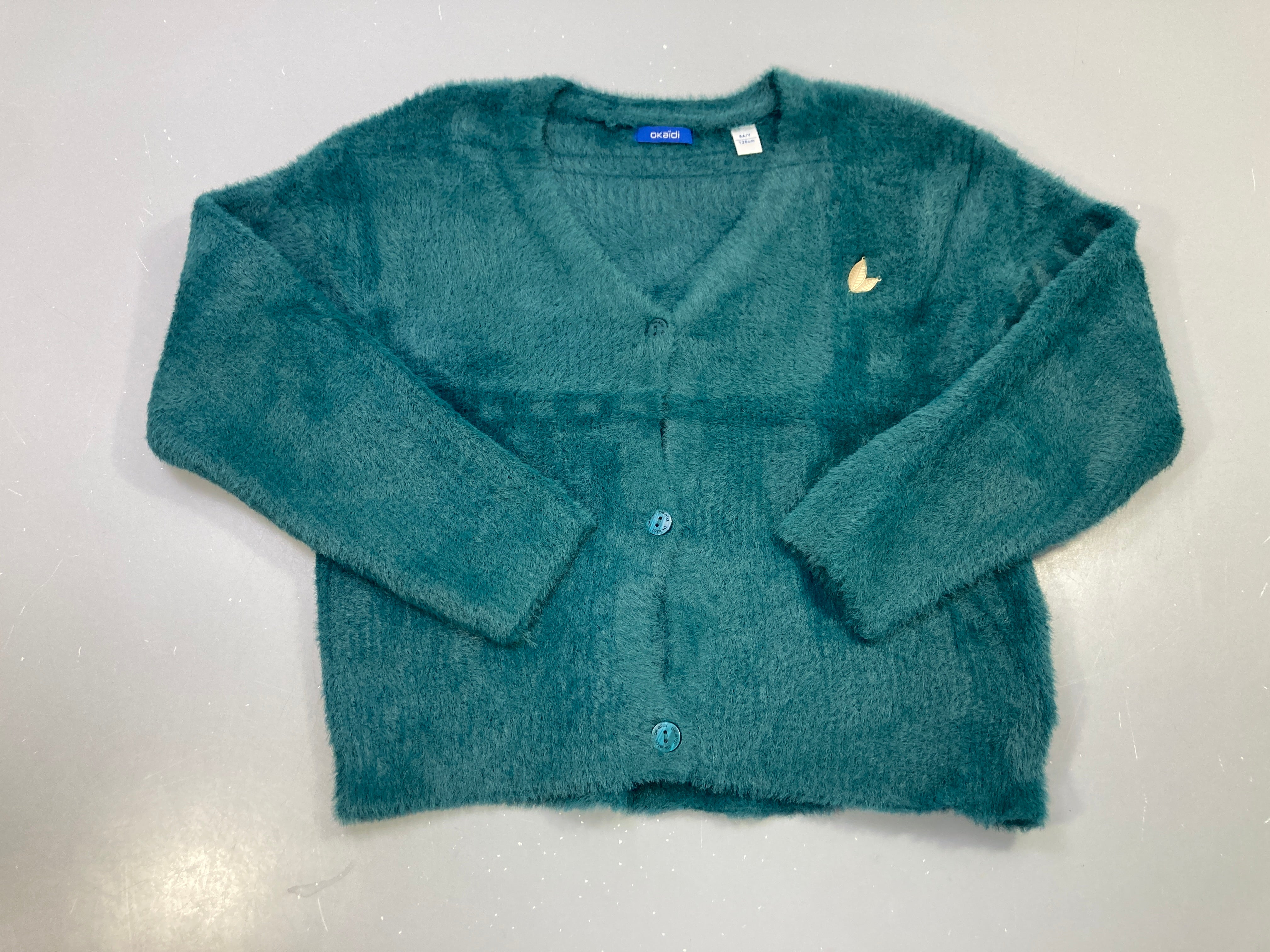 Gilet vert canard duveteux, col V, boutons, broche feuille dorée