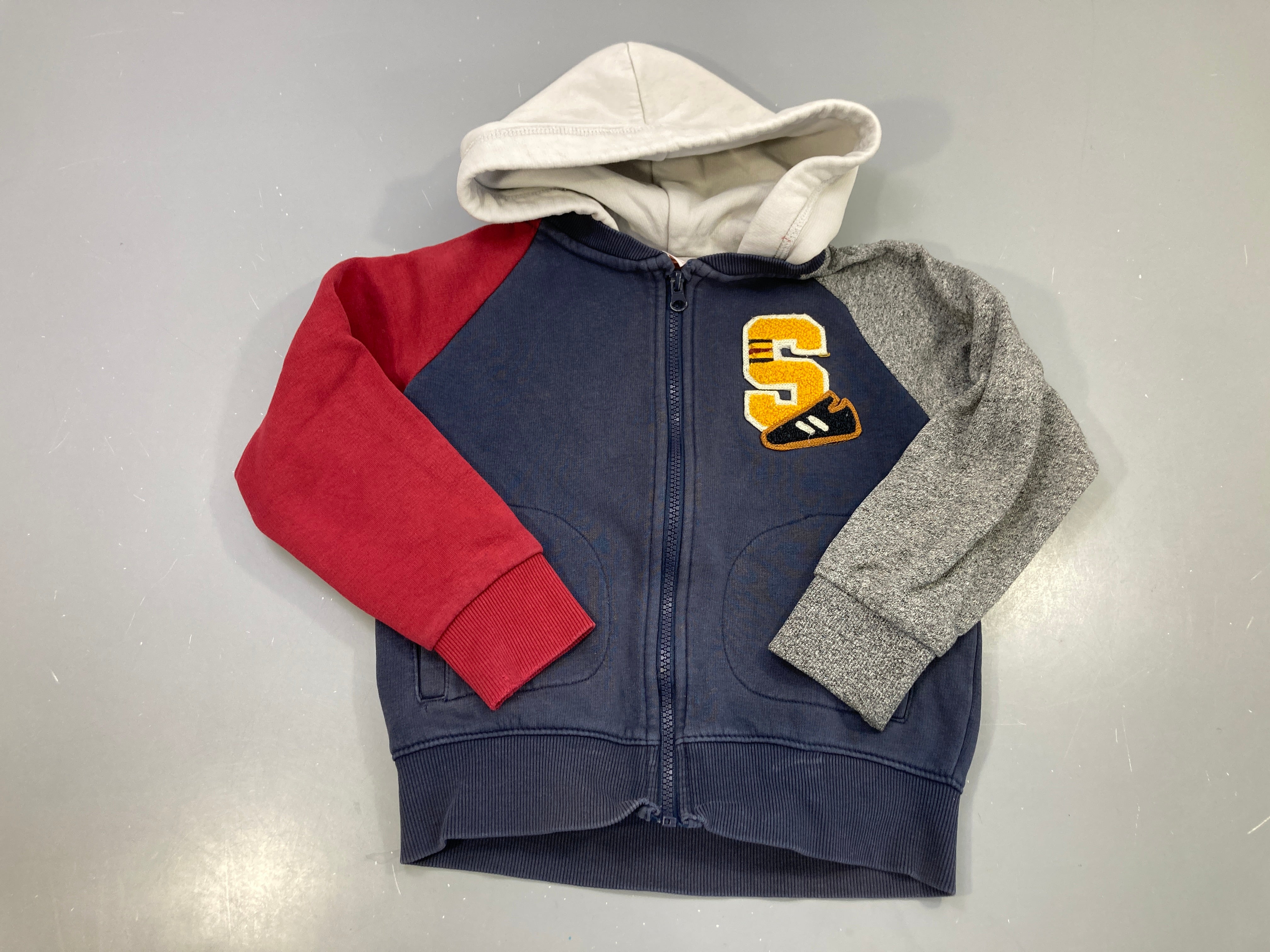 Sweat zippé capuche bleu marine manches rouge et grise, écusson S