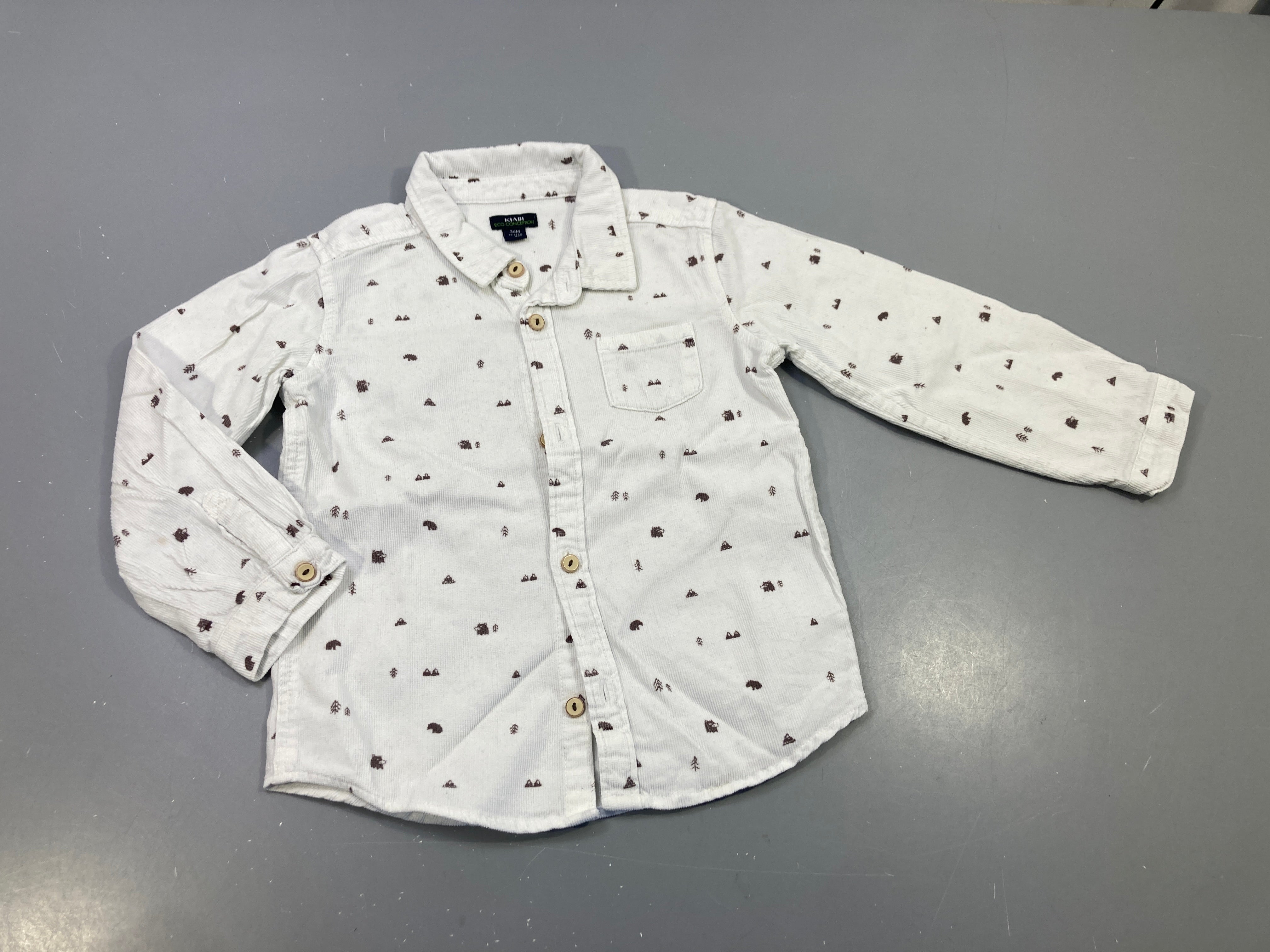 Chemise m.l  en velours côtelé crème  à motifs bruns ( ours, sapins, montagnes),petite tache à la manche
