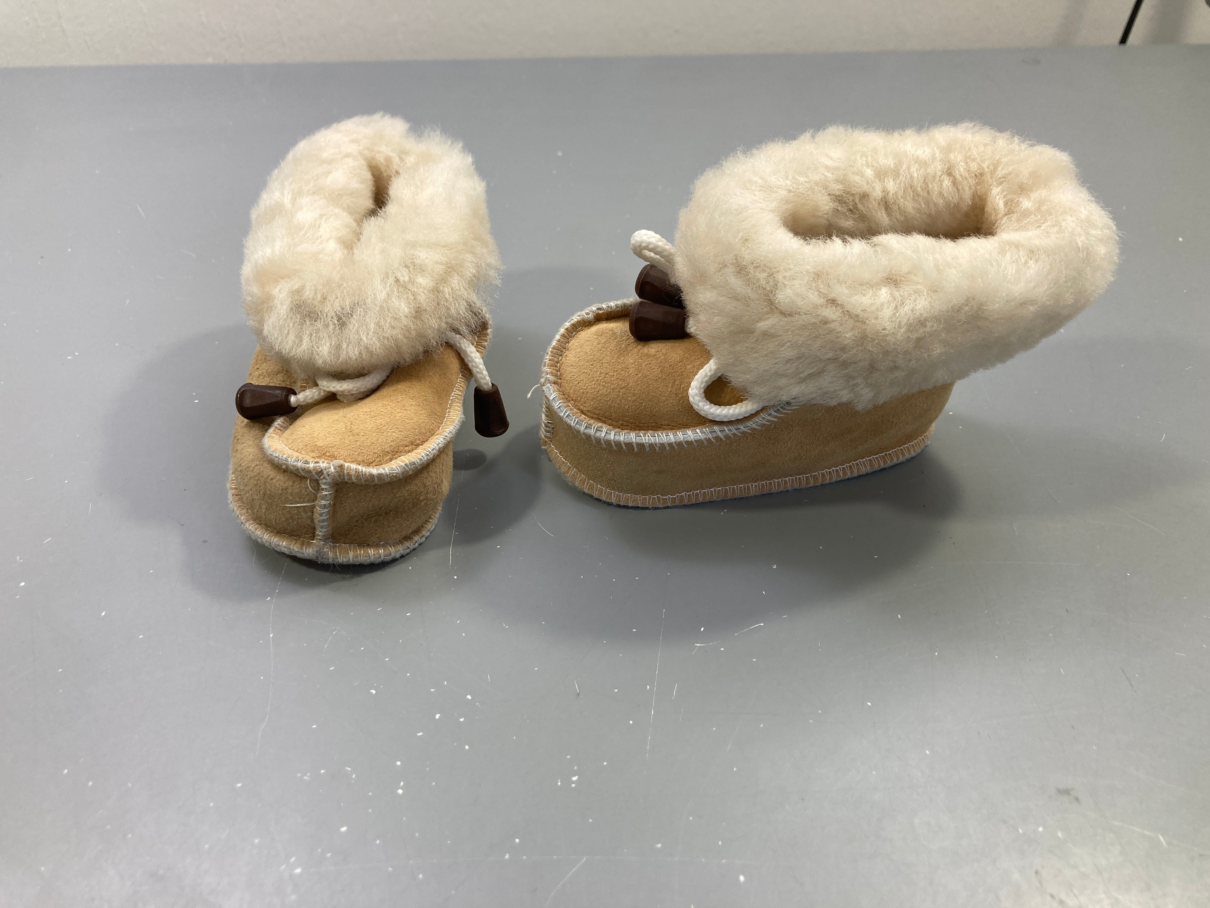 Chaussons camel daim, revers fourrés écrus, lacet