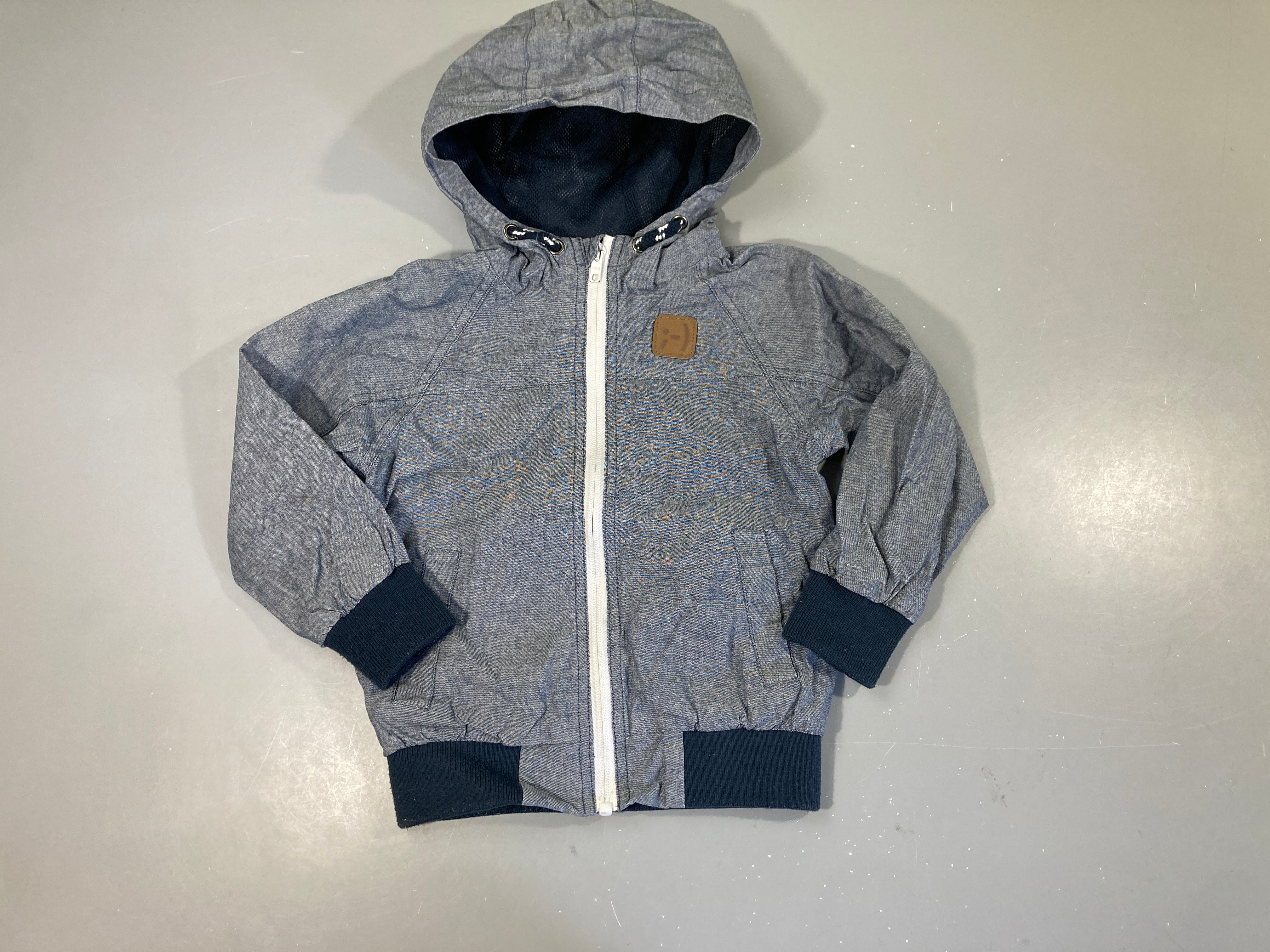 Veste coupe-vent bleu chinéà capuche, bords un peu boulochés