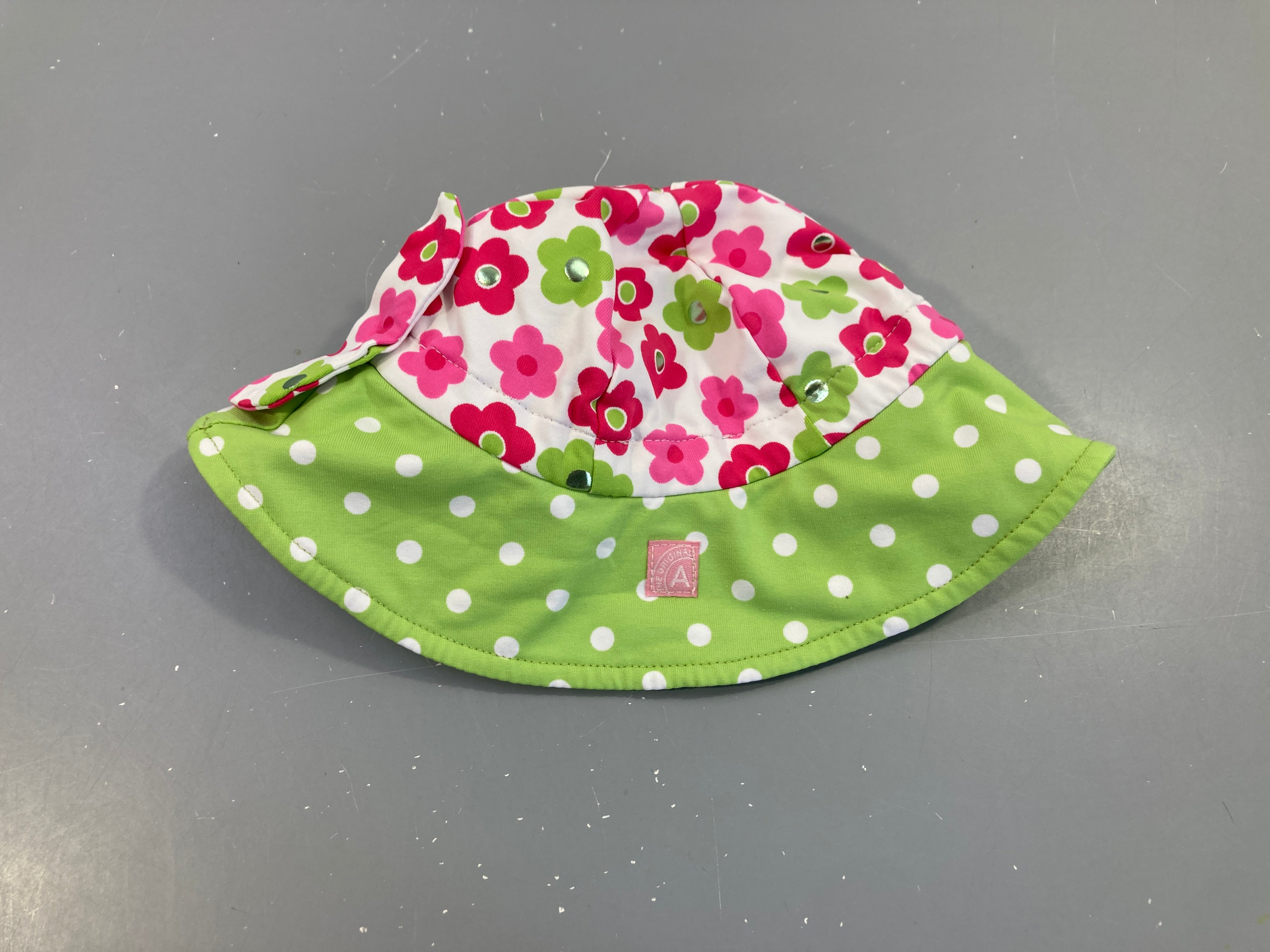 Chapeau vert pois fleurs roses pour la piscine
