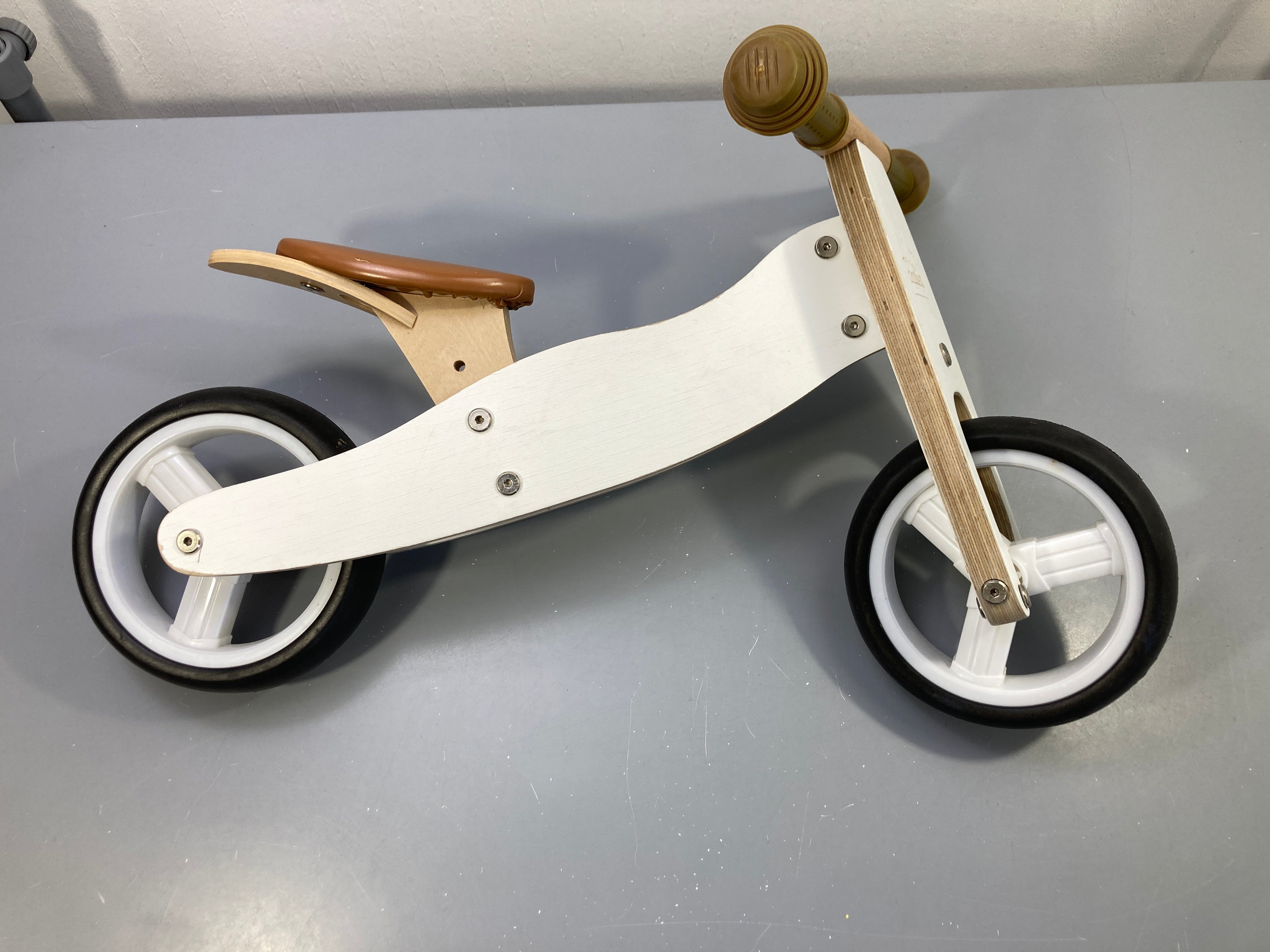 Draisienne en bois blanche et naturelle, Pinolino selle marron, roues noires, petit défaut au guidon