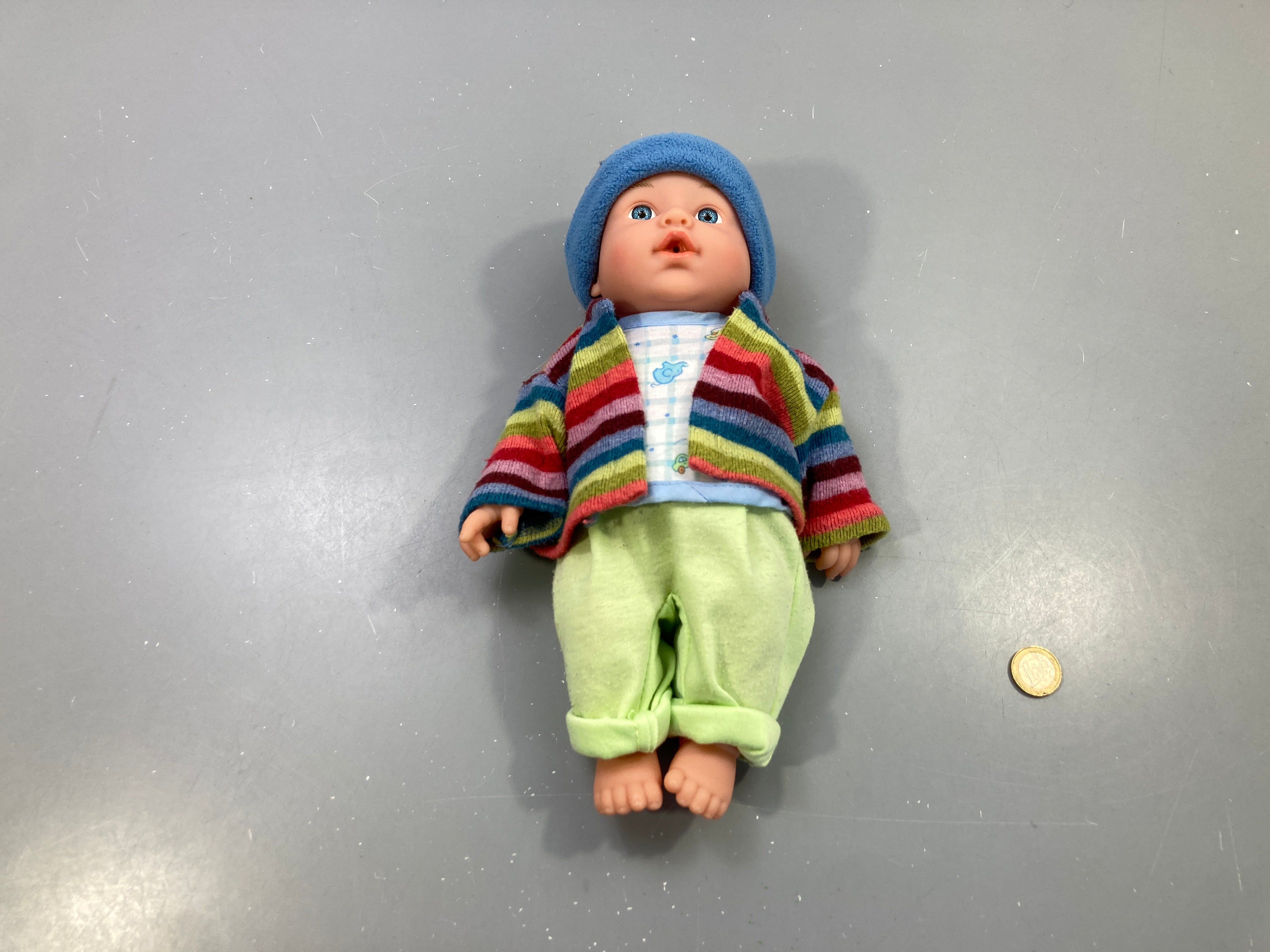 Poupon gilet rayé multicolore, pantalon vert et bonnet bleu, vêtements boulochés