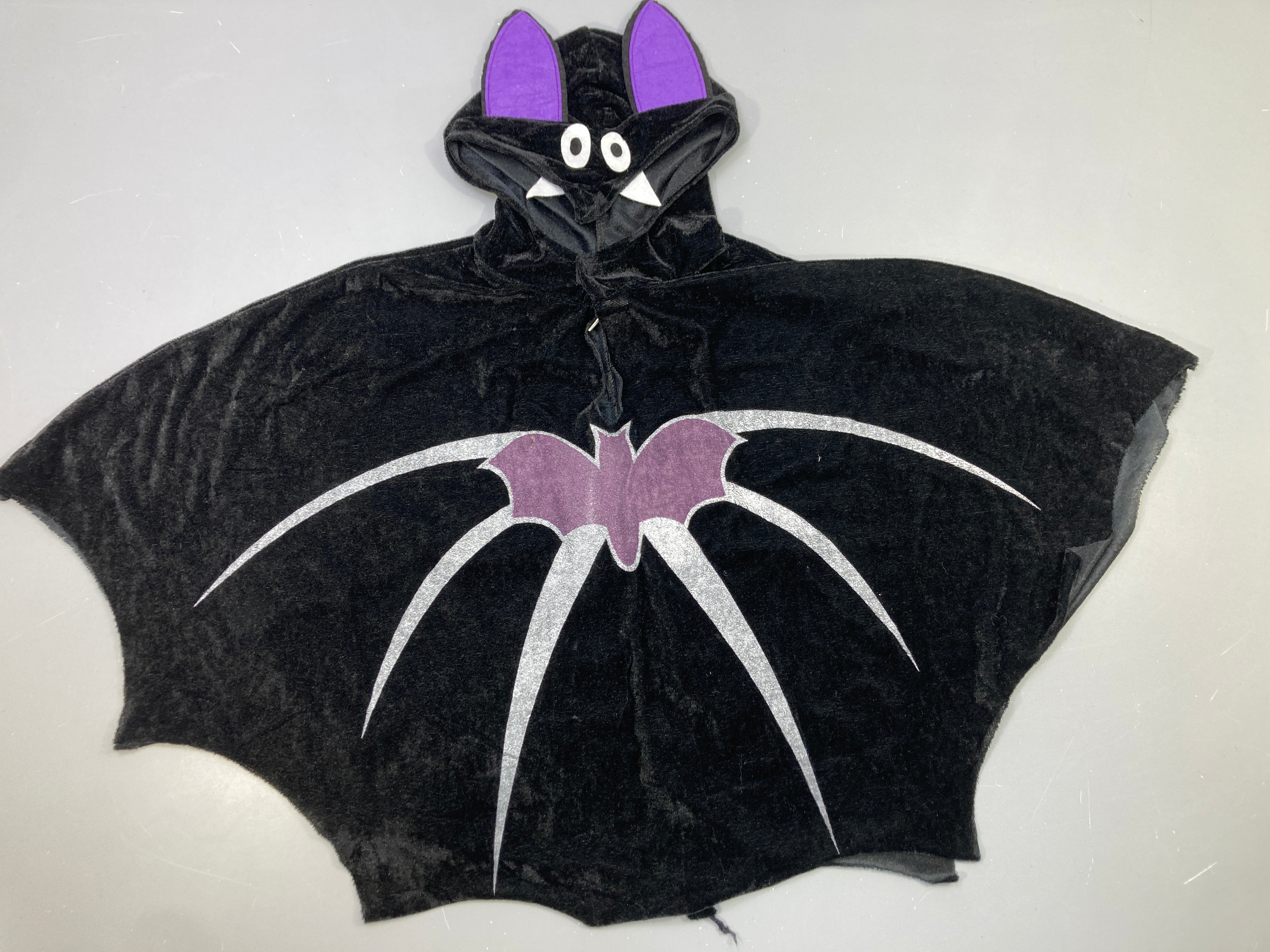 Déguisement cape chauve-souris velours noire, capuche oreilles violettes, motif argenté